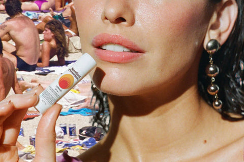 Lip sunscreen applied by a woman at the beach using Standard Procedure SPF lip balm.