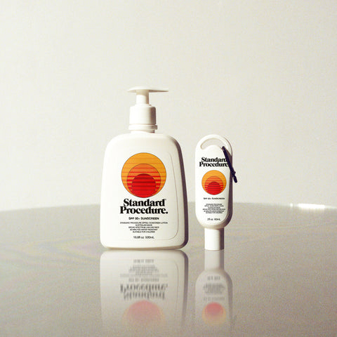 Best natural sunscreen Australia edition by Standard Procedure shown in large and travel-size pump bottles on a reflective surface.