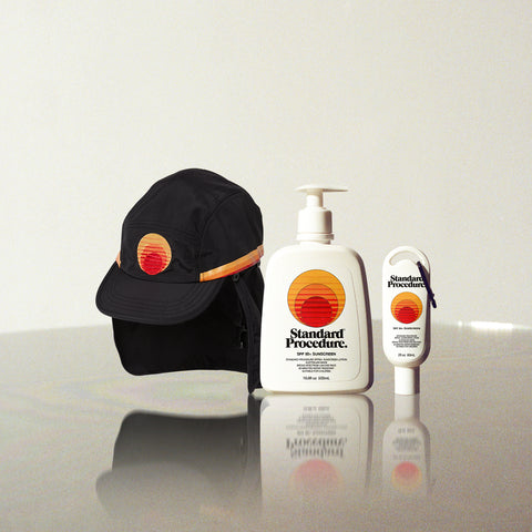 Australian sunscreen products and sun-protective hat displayed together on a reflective surface with a neutral background.