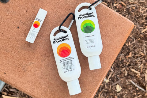 Sunscreen for face with SPF 50+ and aloe vera gel displayed beside a lip balm on an outdoor surface