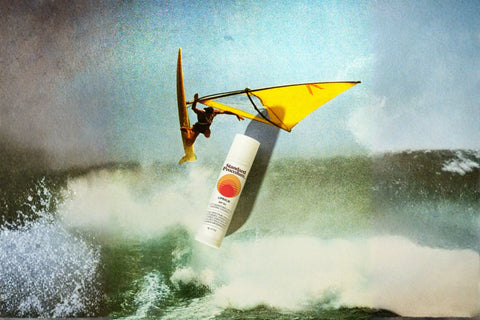 Standard Procedure travel-friendly sunscreen lip balm SPF overlaid on a windsurfer riding ocean waves