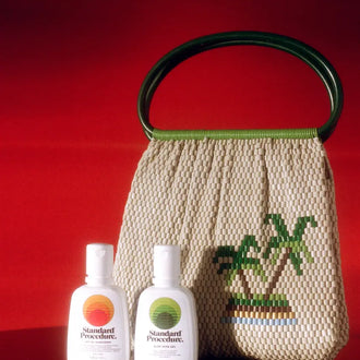 Aloe vera for skin and SPF 50+ sunscreen bottles from Standard Procedure placed beside a woven tropical handbag, highlighting natural hydration and sun protection essentials for after-sun care