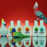 Australian mineral sunscreen bottles from Standard Procedure displayed alongside colorful Australian bird figurines against a red backdrop, highlighting vibrant, nature-inspired skincare