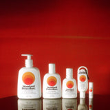Full Standard Procedure SPF 50+ sunscreen range lined up against a deep red backdrop.