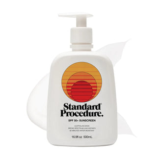 SPF 50 sunscreen for face pump bottle with a subtle lotion smear behind it on a clean white background.