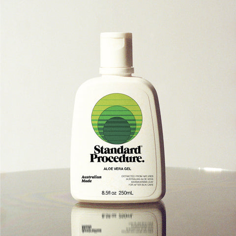 Standard Procedure Aloe Vera Gel 250ml bottle with a flip-top cap on a reflective surface with a grey background.
