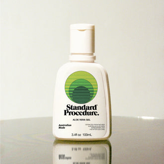 Standard Procedure Aloe Vera Gel 100ml bottle with a flip-top cap on a reflective surface.