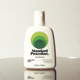 Standard Procedure Aloe Vera Gel 250ml bottle with a flip-top cap and green logo on a reflective surface.