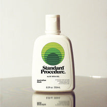 Standard Procedure Aloe Vera Gel 250ml bottle with a flip-top cap and green logo on a reflective surface.