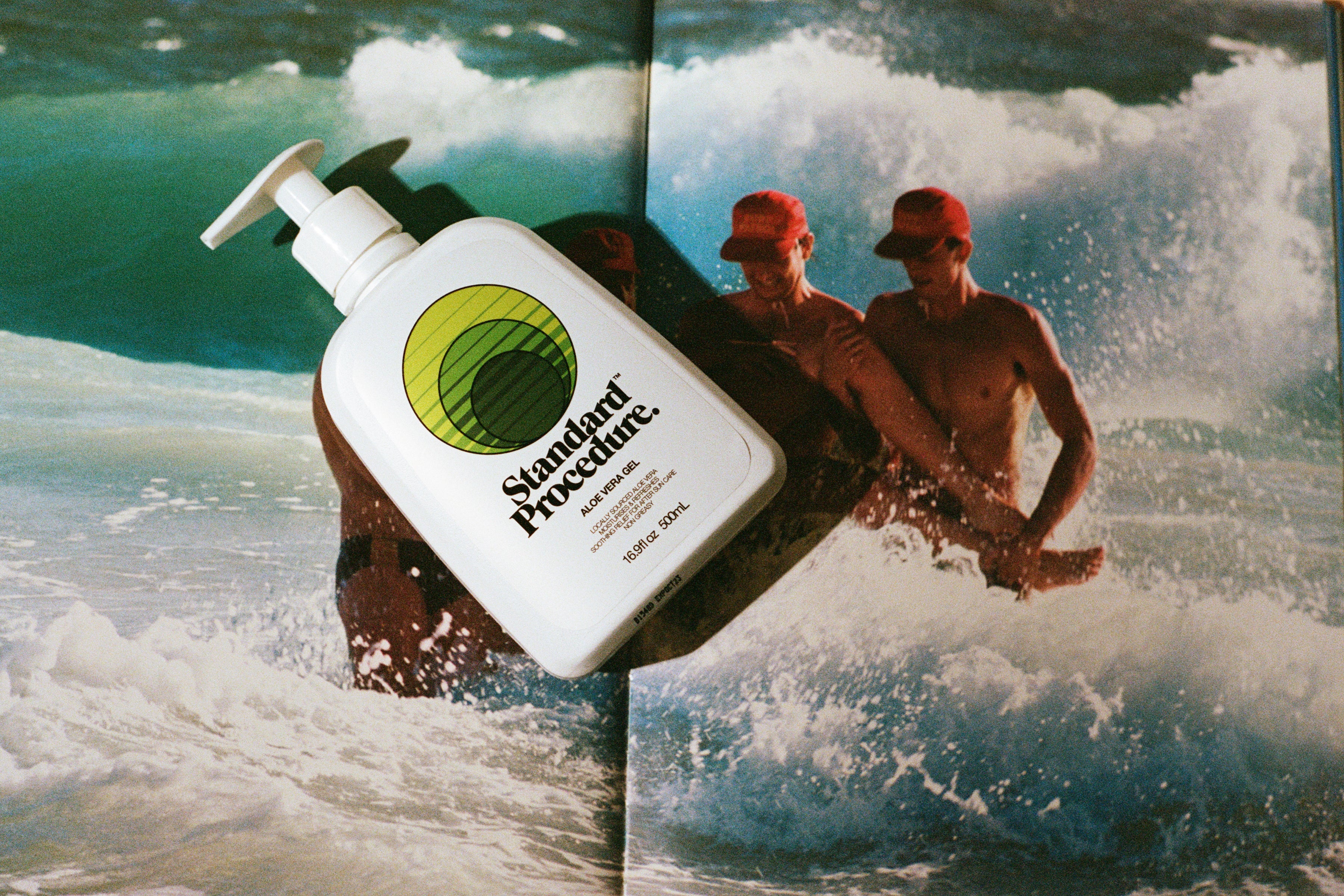 Standard Procedure Aloe Vera Gel 500ml bottle with a white pump top displayed against an ocean surf backdrop.