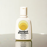 Standard Procedure Moisturising Protection SPF 15 100ml bottle on a reflective surface with a neutral background.