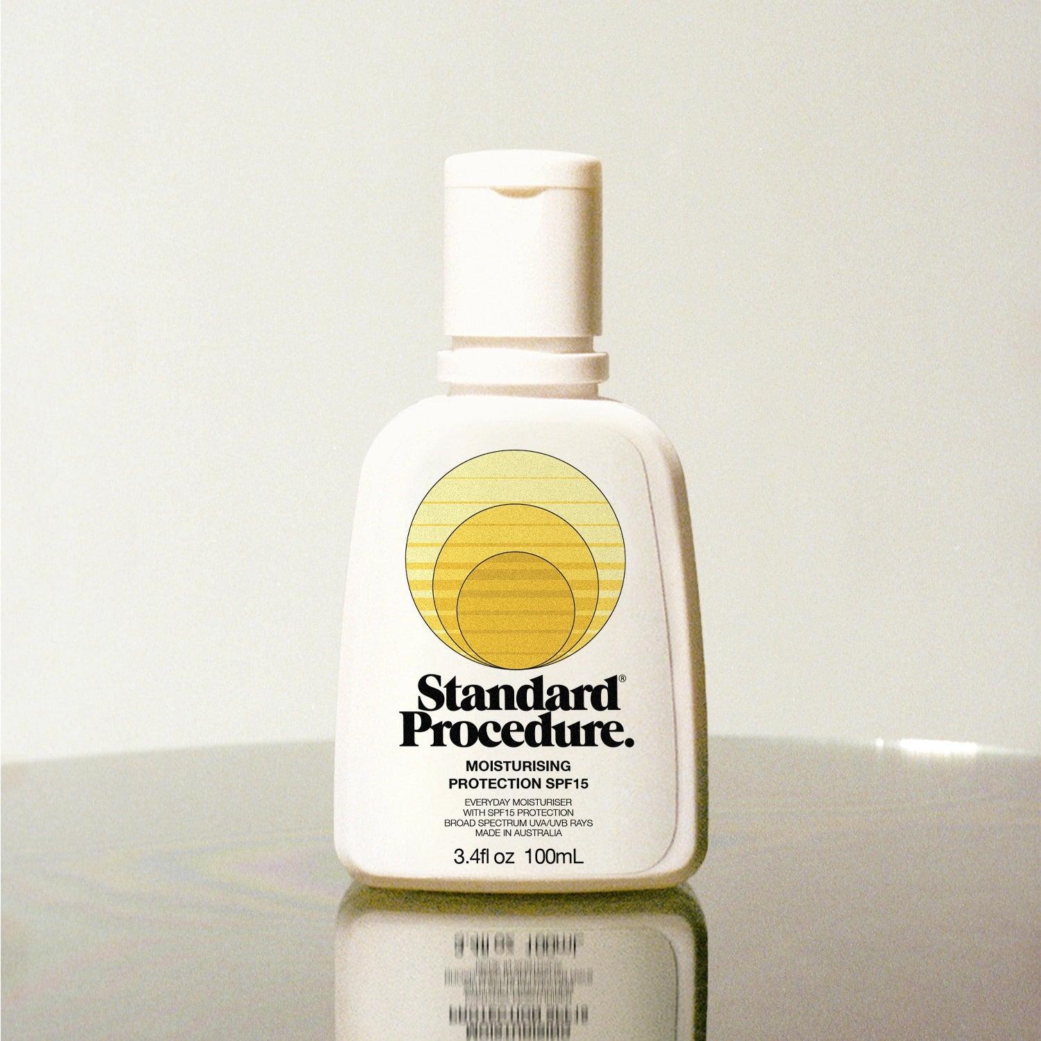Standard Procedure Moisturising Protection SPF 15 100ml bottle on a reflective surface with a neutral background.
