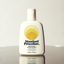Standard Procedure Moisturising Protection SPF 15 250ml bottle with a flip-top cap on a reflective surface.