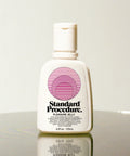 Standard Procedure Pleasure Jelly 125ml bottle with a pump top and pink logo on a reflective surface.