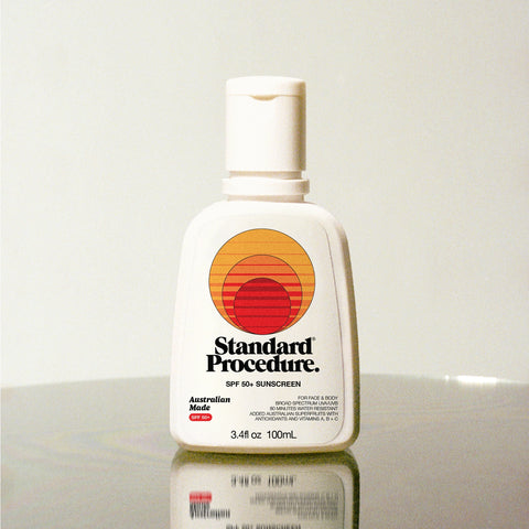 Standard Procedure SPF 50 Sunscreen 100ml bottle on a reflective surface with a neutral studio background.