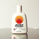 Standard Procedure SPF 50 Sunscreen 250ml bottle with a flip-top cap on a reflective surface.