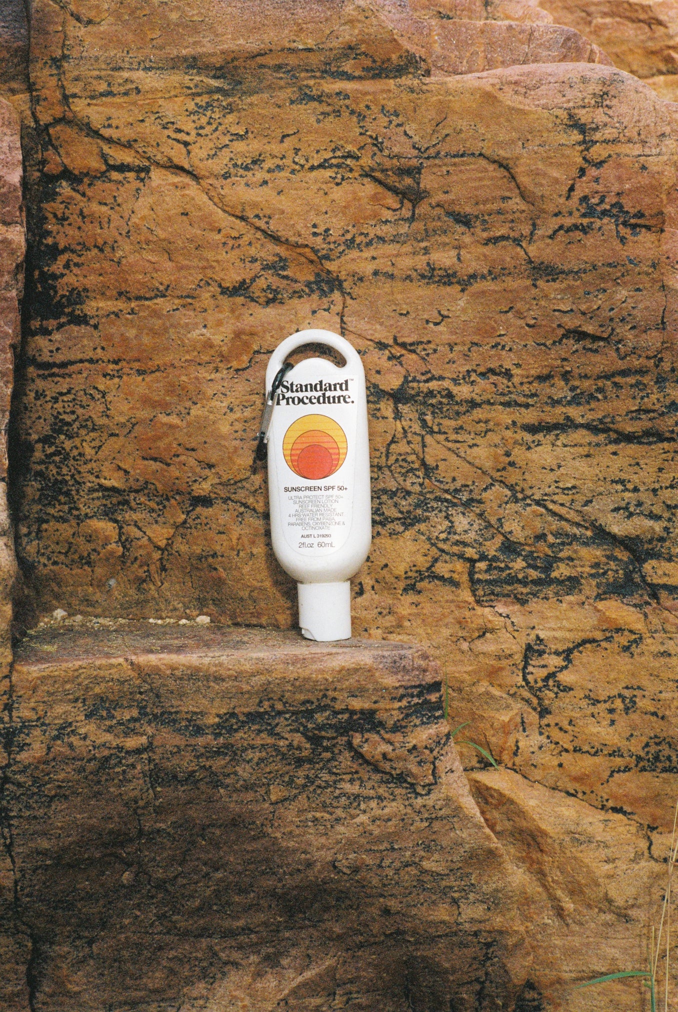Australian made sunscreen from Standard Procedure placed against rugged rock formations, emphasizing durability, outdoor protection, and locally crafted SPF 50+ skincare