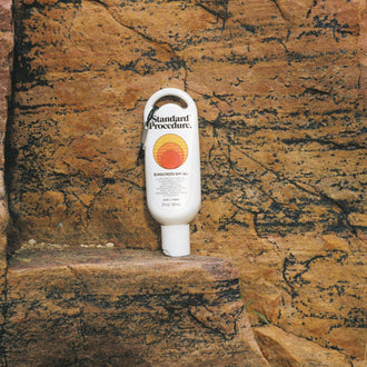 Australian made sunscreen from Standard Procedure placed against rugged rock formations, emphasizing durability, outdoor protection, and locally crafted SPF 50+ skincare