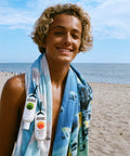 Person on a beach with a towel and sunscreen