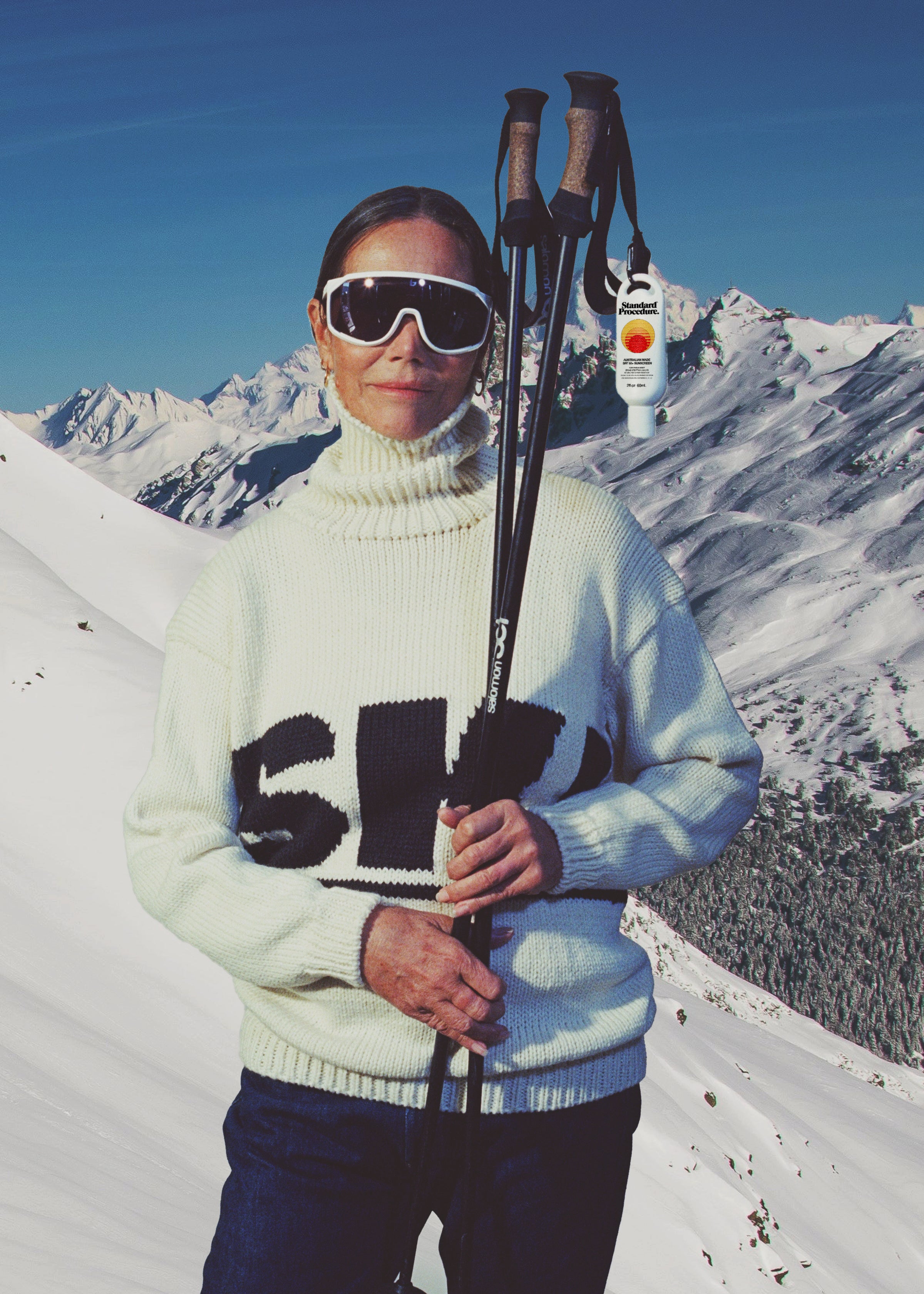 Person in ski gear with skis and poles against a snowy mountain backdrop