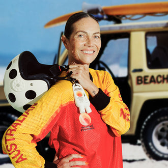 Australian lifesaver carrying Standard Procedure SPF 50+ travel sunscreen clipped to her patrol uniform.