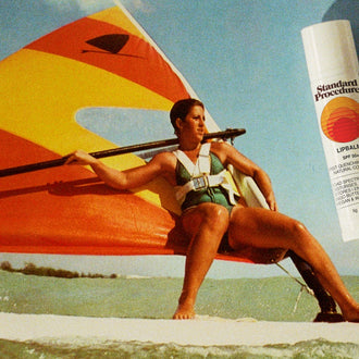 Lip balm with vitamin C and SPF shown beside a woman windsurfing on the ocean under a bright sunny sky.