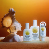 Three Standard Procedure SPF 15 moisturiser bottles beside a seashell on towel in sunset glow.