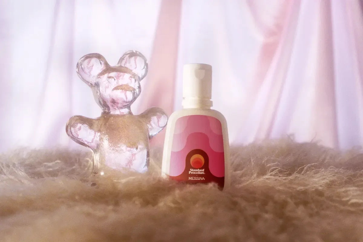 Standard Procedure x Messina water-based personal lubricant beside a clear gummy bear figure.
