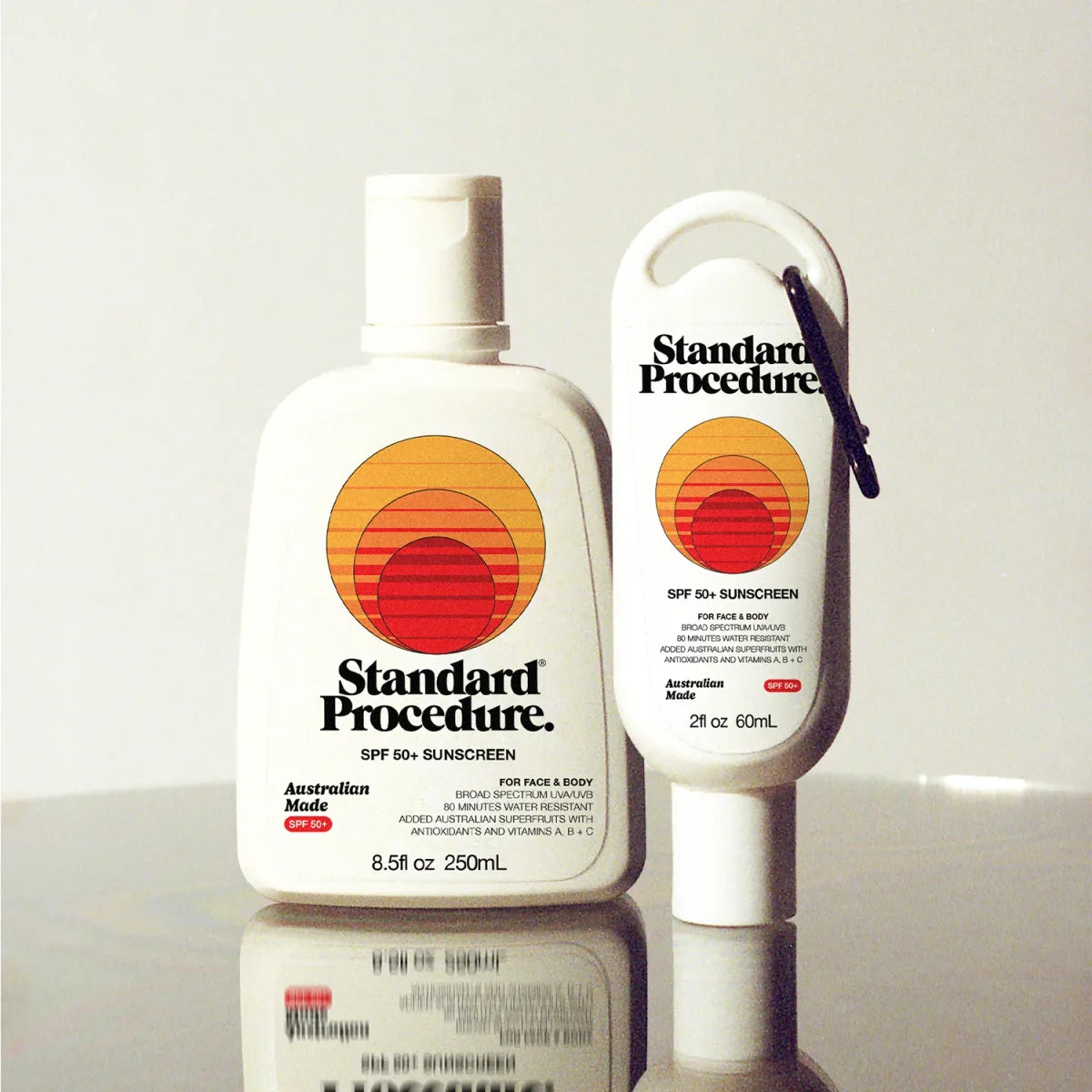Standard Procedure SPF 50+ sunscreen kit: full-size 250mL bottle beside clip-on 60mL mini.