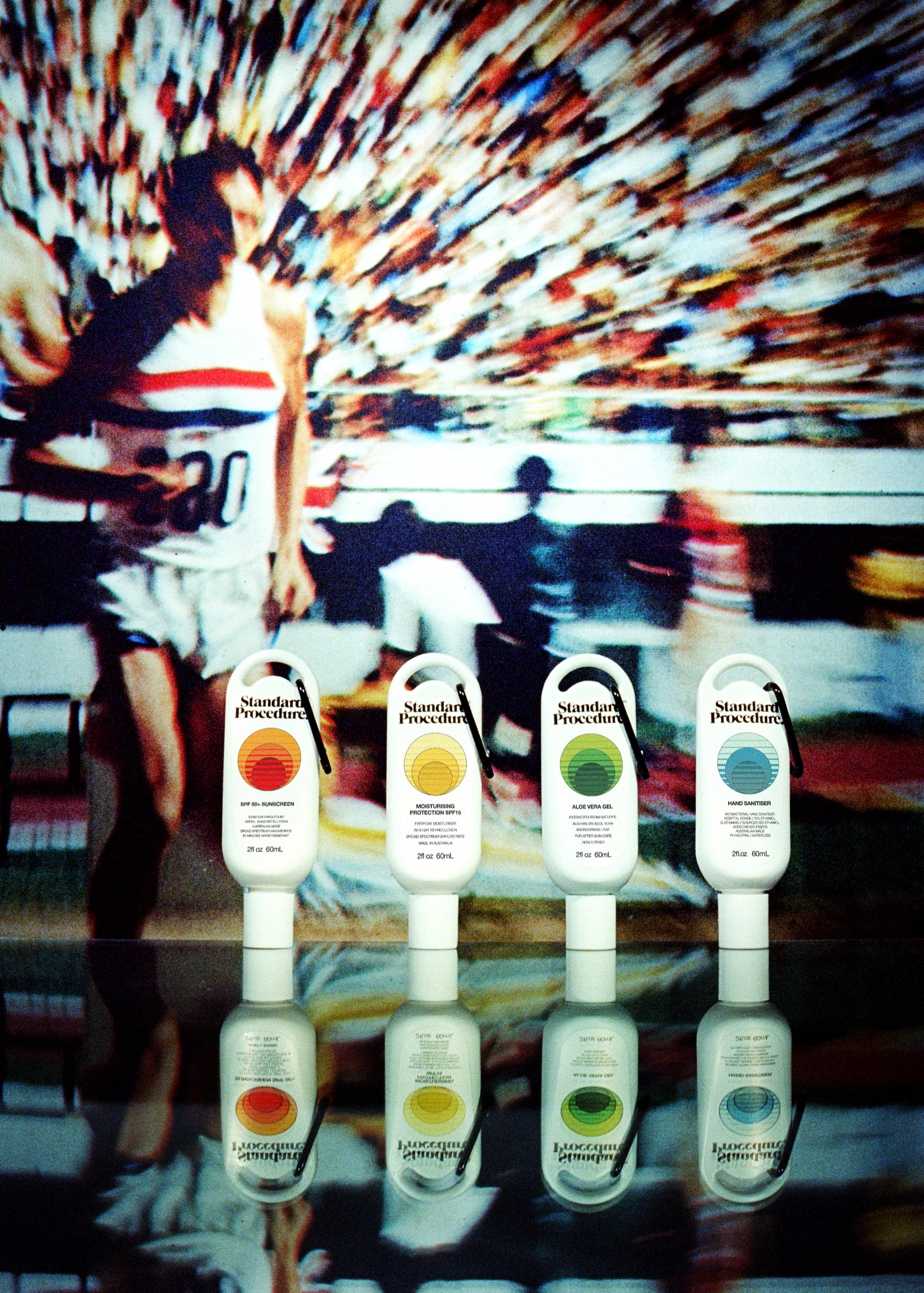 Clip-on aloe vera gel lined up beside sunscreen and sanitiser bottles against a retro tennis backdrop.