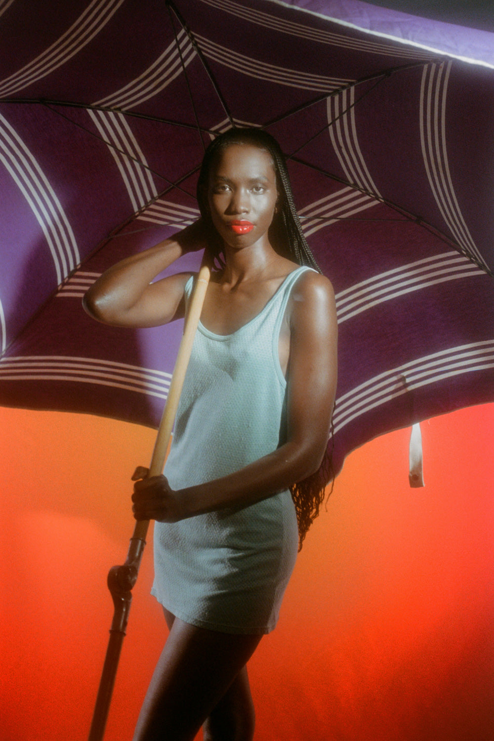 Editorial sun protection campaign for Standard Procedure SPF 15 moisturiser, model shaded under a striped parasol.