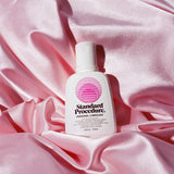 Standard Procedure aloe vera personal lubricant bottle nestled in draped pink satin sheets.