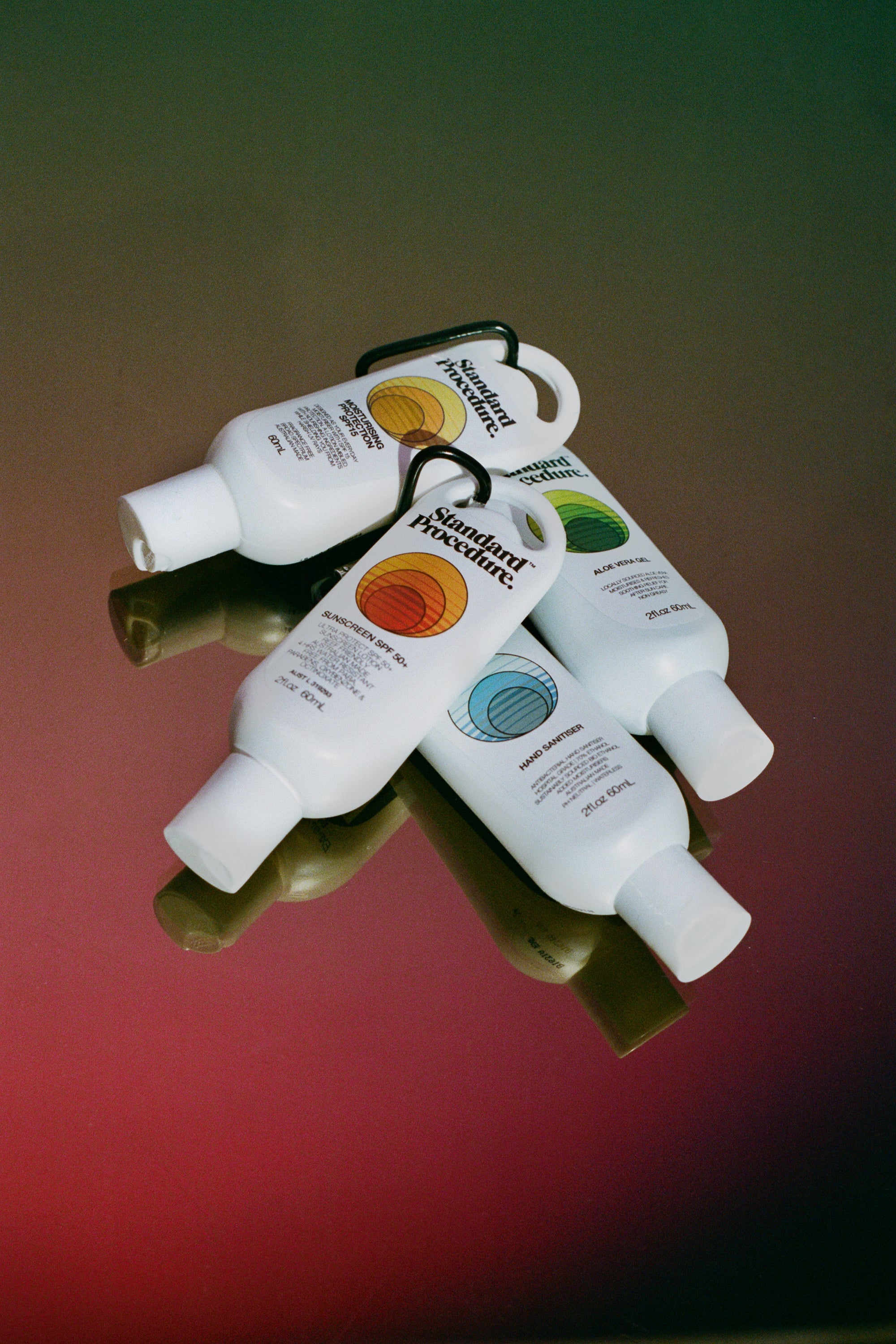 Clip-on 60ml travel kit with aloe vera gel, sunscreen, SPF moisturiser, and hand sanitiser bottles.