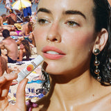 SPF 50 lip balm held by a woman at the beach with a crowd of sunbathers in the background.